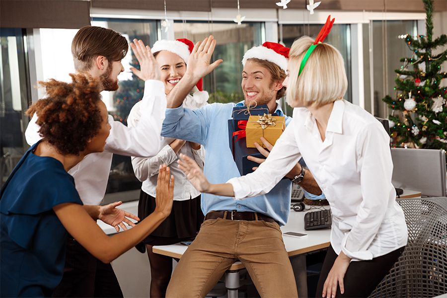 a group of colleagues giving a Christmas gift to their client and cheering