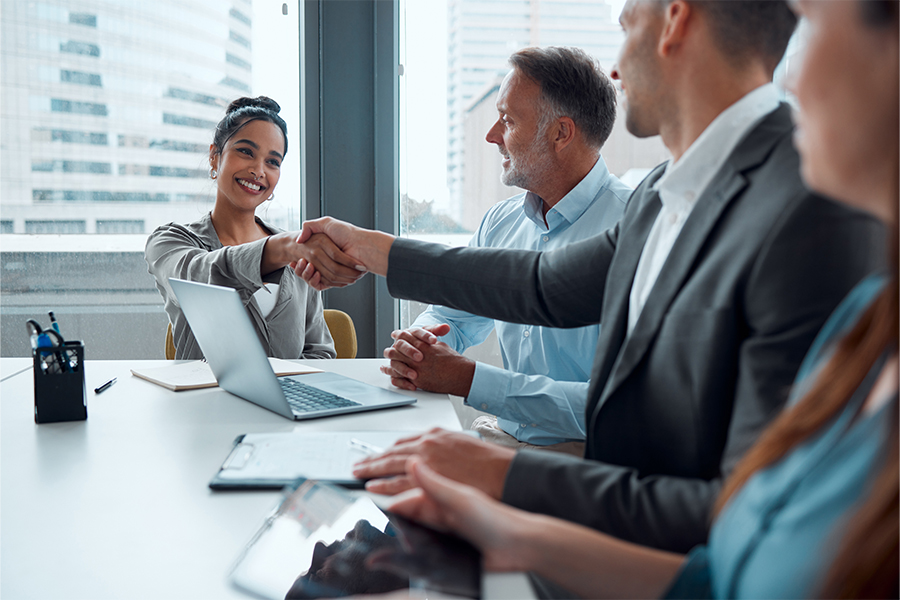 A group of male senior employees shaking a hand of a female employee in a sign of appreciation