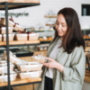 A woman examines a chocolate gift on a shelf, contemplating the perfect choice for a special occasion